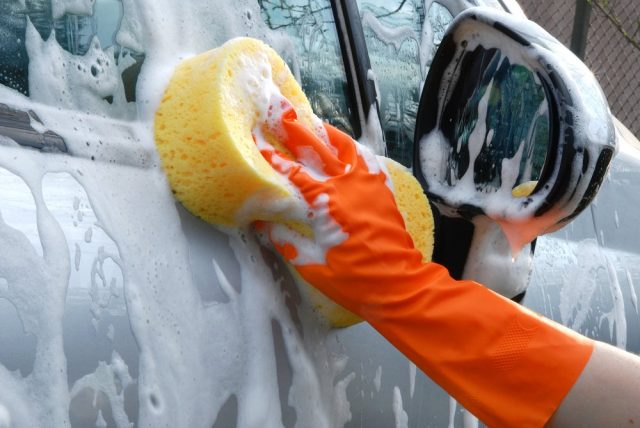 Umývanie auta s hubkou v rukaviciach